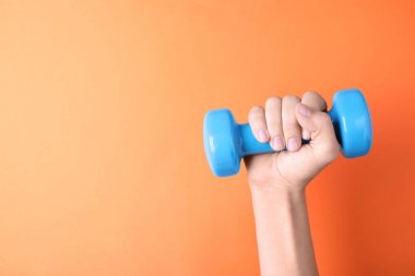 Renk arka plan üzerinde vinil dumbbell tutan kadın, metin için boşluk ile çekim