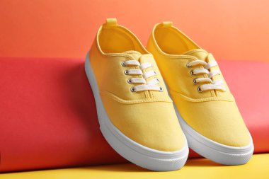 Renkli arka plan üzerinde rahat spor ayakkabılar ve kağıt rulo, closeup