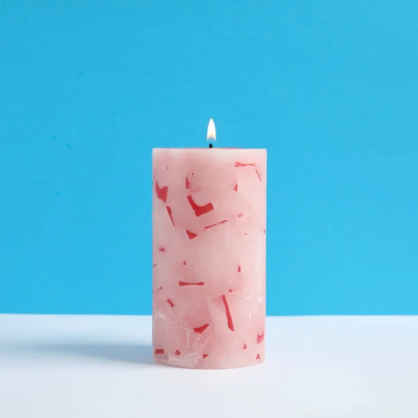 Zapálené voskové svíčky na barevném pozadí — Stock fotografie