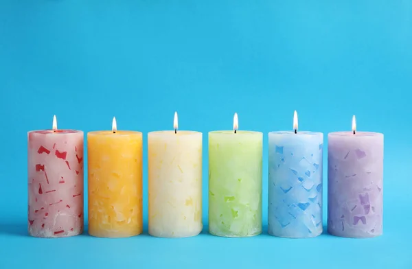 Alight scented wax candles on color background