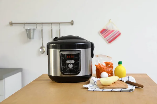 New modern multi cooker and products on table in kitchen — Stock Photo, Image