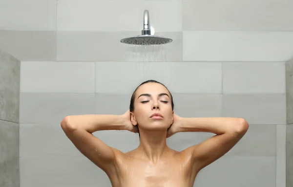 Beautiful young woman taking shower in spa center — Stock Photo, Image