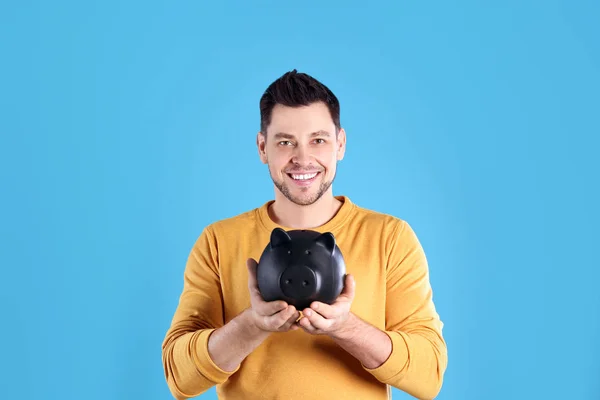 Man with piggy bank on color background — Stock Photo, Image