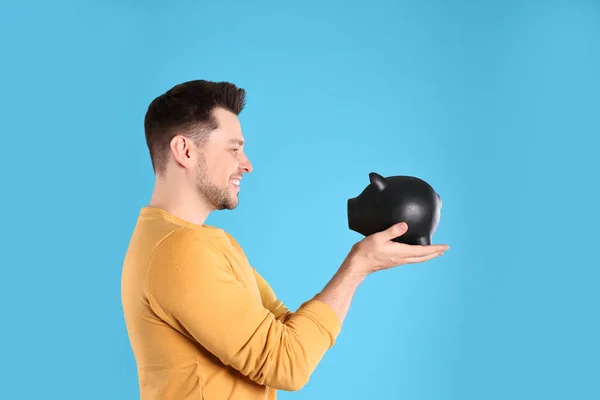 Man with piggy bank on color background — Stock Photo, Image