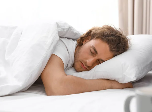 Όμορφος νεαρός άντρας που κοιμάται στο μαξιλάρι στο σπίτι. Κατάκλιση — Φωτογραφία Αρχείου
