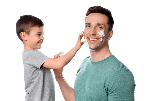 Otec a jeho syn aplikováním pěny na holení na bílém pozadí — Stock fotografie