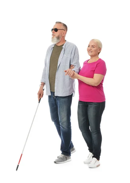 白い背景に長いケーンを持つ盲目の人を助ける成熟した女性 — ストック写真