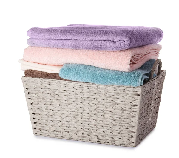 Плетеная корзина для белья с чистыми полотенцами на белом фоне — стоковое фото