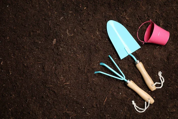 Flat lay composition with gardening equipment on soil, space for text — Stock Photo, Image