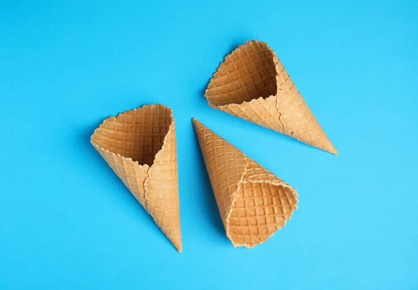 Waffle empty ice cream cones on color background, flat lay — Stock Photo, Image