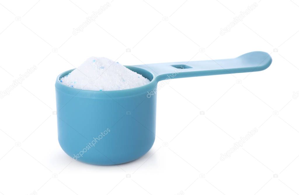 Laundry detergent in plastic measuring scoop on white background