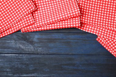 Renkli ahşap arka plan üzerinde damalı piknik peçeteler, üst görünüm. Metin alanı