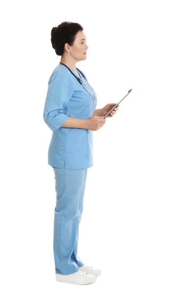 白で隔離されたクリップボードを持つスクラブで女性医師の完全な長さの肖像画。医療スタッフ — ストック写真