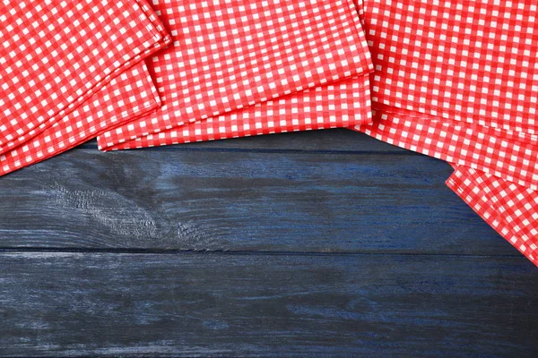 Renkli ahşap arka plan üzerinde damalı piknik peçeteler, üst görünüm. Metin alanı