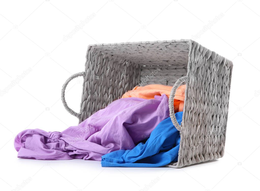 Laundry basket with scattered dirty clothes isolated on white