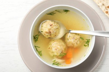 Beyaz ahşap masa üzerinde Yahudi matzoh topları çorba Kase, üst görünümü