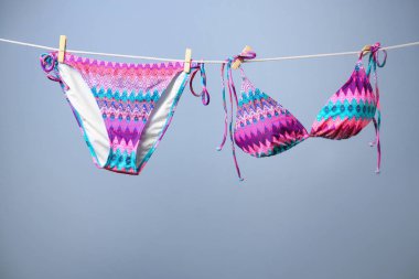 Renkli arka plana karşı ipe asılı şık bikini