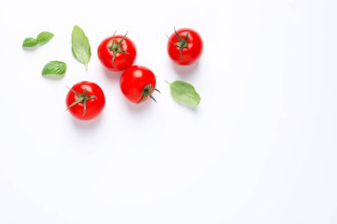 Beyaz arka planda olgun kiraz domates ve fesleğen yaprakları ile Kompozisyon, üst görünümü