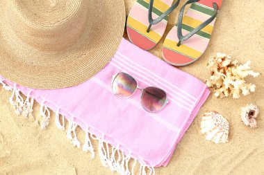 Kum üzerinde farklı şık plaj aksesuarları seti, görünümün üstünde