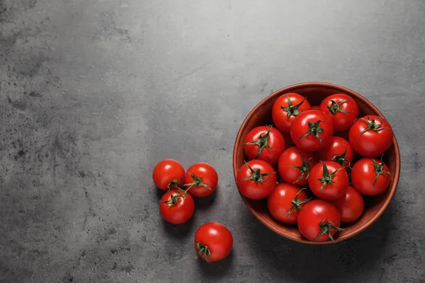 Tigela com tomates cereja maduros no fundo da cor, vista superior. Espaço para texto — Fotografia de Stock