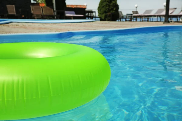 Anillo inflable brillante flotando en la piscina en el día soleado, al aire libre. Espacio para texto — Foto de Stock