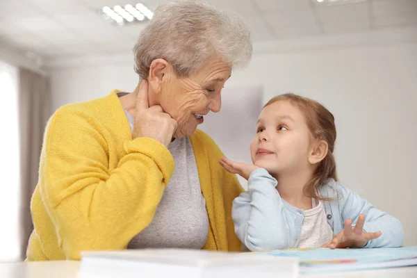 Fille mignonne et sa grand-mère lecture livre à la maison — Photo