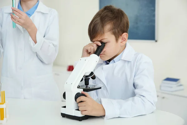 Étudiant regardant à travers le microscope à table en classe de chimie — Photo