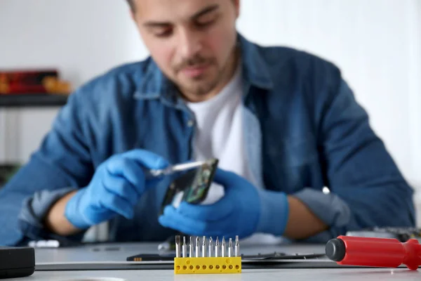 Tecnico riparare smartphone rotto a tavola, concentrarsi sui bit di sicurezza del cacciavite. Spazio per testo — Foto Stock