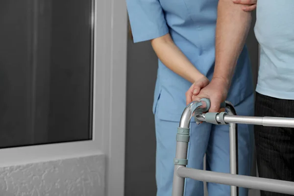 Infirmière aidant le patient âgé avec marcheur à l'hôpital, gros plan — Photo