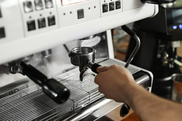 Barista cleaning portafilter at coffee machine in cafe, closeup — Stock Photo, Image