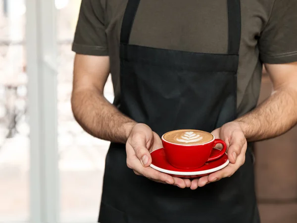 Barista with cup of coffee in shop, closeup. Space for text — Stock Photo, Image