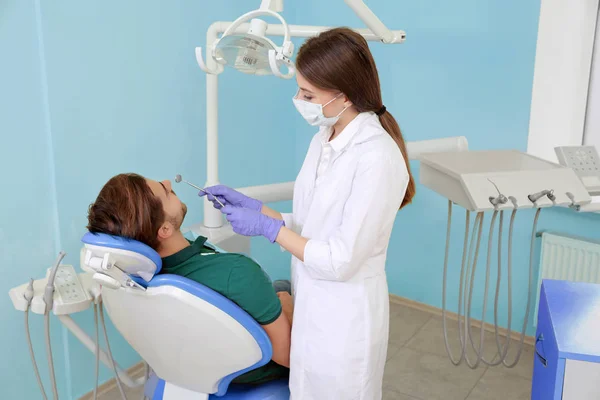 Dentista profissional e paciente na clínica moderna — Fotografia de Stock