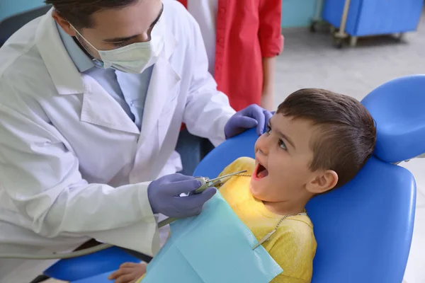 Dentiste professionnel travaillant avec peu de patients dans une clinique moderne — Photo