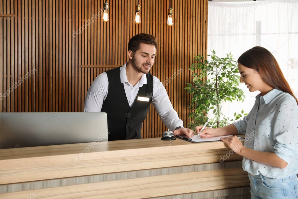 Receptionist registering client at desk in lobby