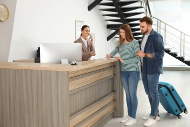 Otelde resepsiyonda müşterilerle çalışan profesyonel resepsiyonist