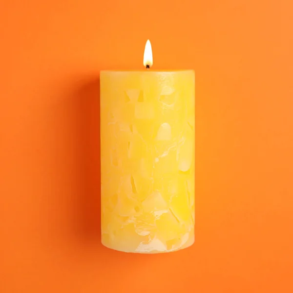 Alight scented wax candle on color background — Stock Photo, Image