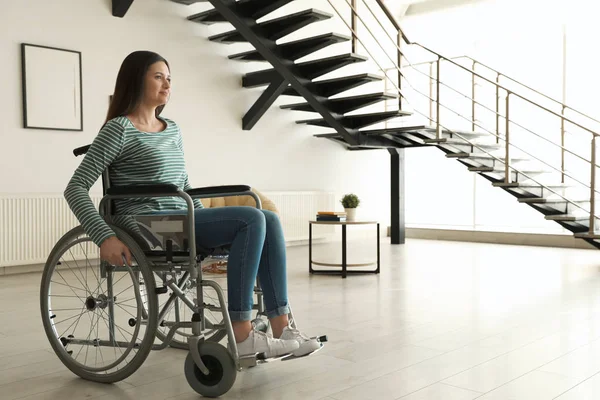 Jonge vrouw in rolstoel binnenshuis. Ruimte voor tekst — Stockfoto