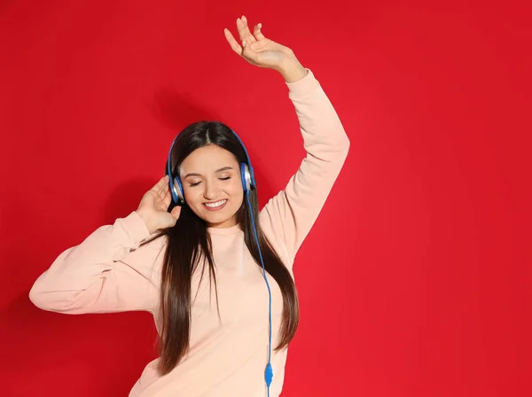 Attraktive junge Frau genießt Musik in Kopfhörern auf farbigem Hintergrund. Raum für Text — Stockfoto