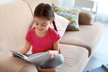 Kapalı kanepede sevimli çocuk okuma kitabı