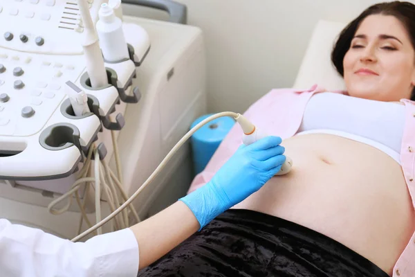 Jonge zwangere vrouw ondergaan echografie in kliniek — Stockfoto