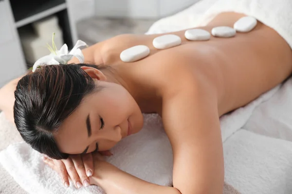 Mooie Aziatische vrouw krijgt Hot Stone massage in Spa Salon — Stockfoto