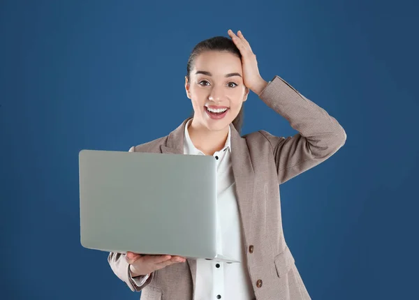 Porträt einer glücklichen jungen Frau in Bürokleidung mit Laptop auf farbigem Hintergrund — Stockfoto