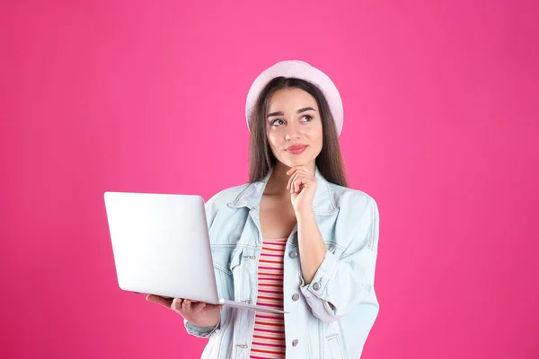 Portrait de jeune femme en tenue décontractée avec ordinateur portable sur fond de couleur — Photo