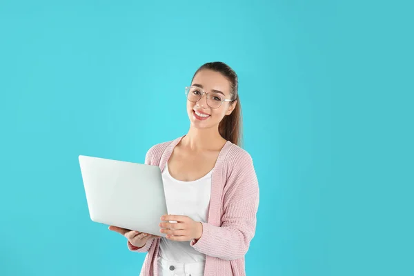 Retrato de mujer joven en traje casual con portátil sobre fondo de color — Foto de Stock