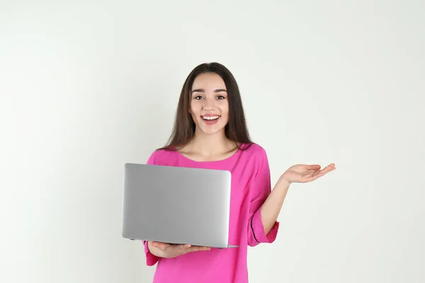 Portrait de jeune femme en tenue décontractée avec ordinateur portable sur fond clair — Photo