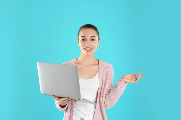 Porträtt av ung kvinna i casual outfit med laptop på färg bakgrund — Stockfoto