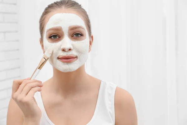Krásná žena, která používá domácí masku na obličeji uvnitř — Stock fotografie