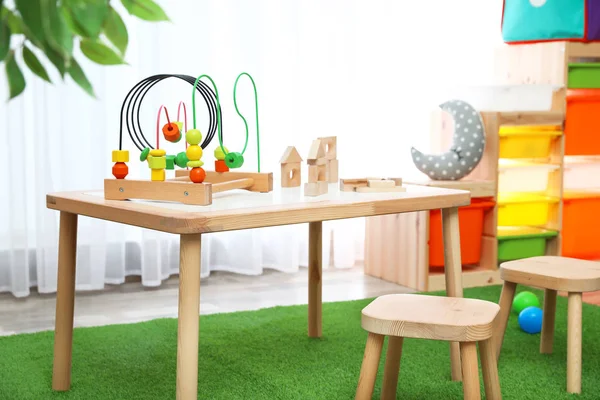Stilvolles Spielzimmer-Interieur mit Spielzeug und modernen Holzmöbeln — Stockfoto