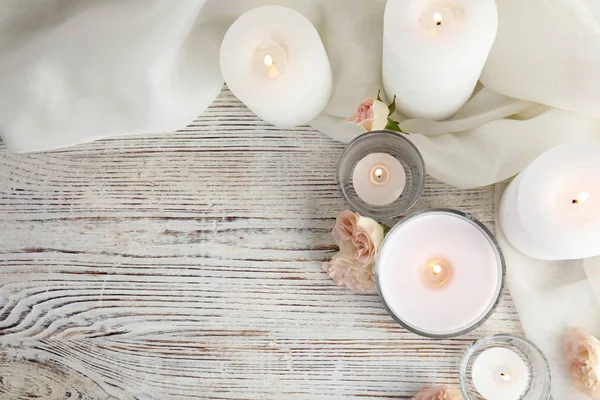 Composición plana con velas aromáticas ardientes y rosas sobre mesa de madera. Espacio para texto —  Fotos de Stock