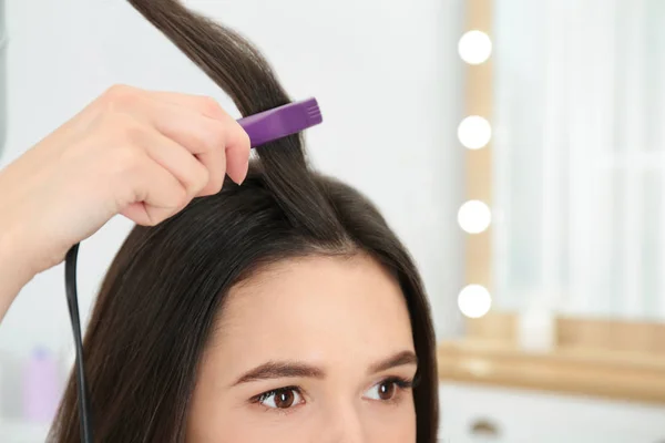 Parrucchiere con ferro piatto moderno per acconciare i capelli del cliente in salone, primo piano. Spazio per testo — Foto Stock